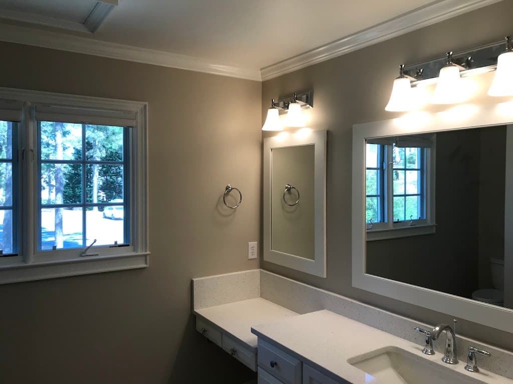 Finished bathroom remodel with double vanity, granite counters, and new lighting